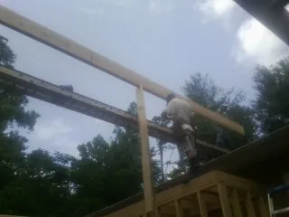 Carpenter setting a ridge beam over a new addition frame — Ice Dam Removal by Roofing Brothers in Spearfish